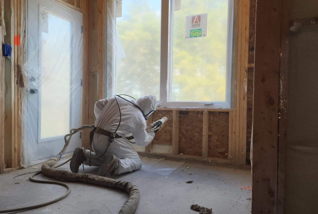 Licensed installer applying closed-cell spray foam insulation in Moncton home attic
